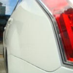 Before and after photographs of a damaged white Subaru that was repaired by Elite Paint & Body Shop in West Palm Beach, Florida